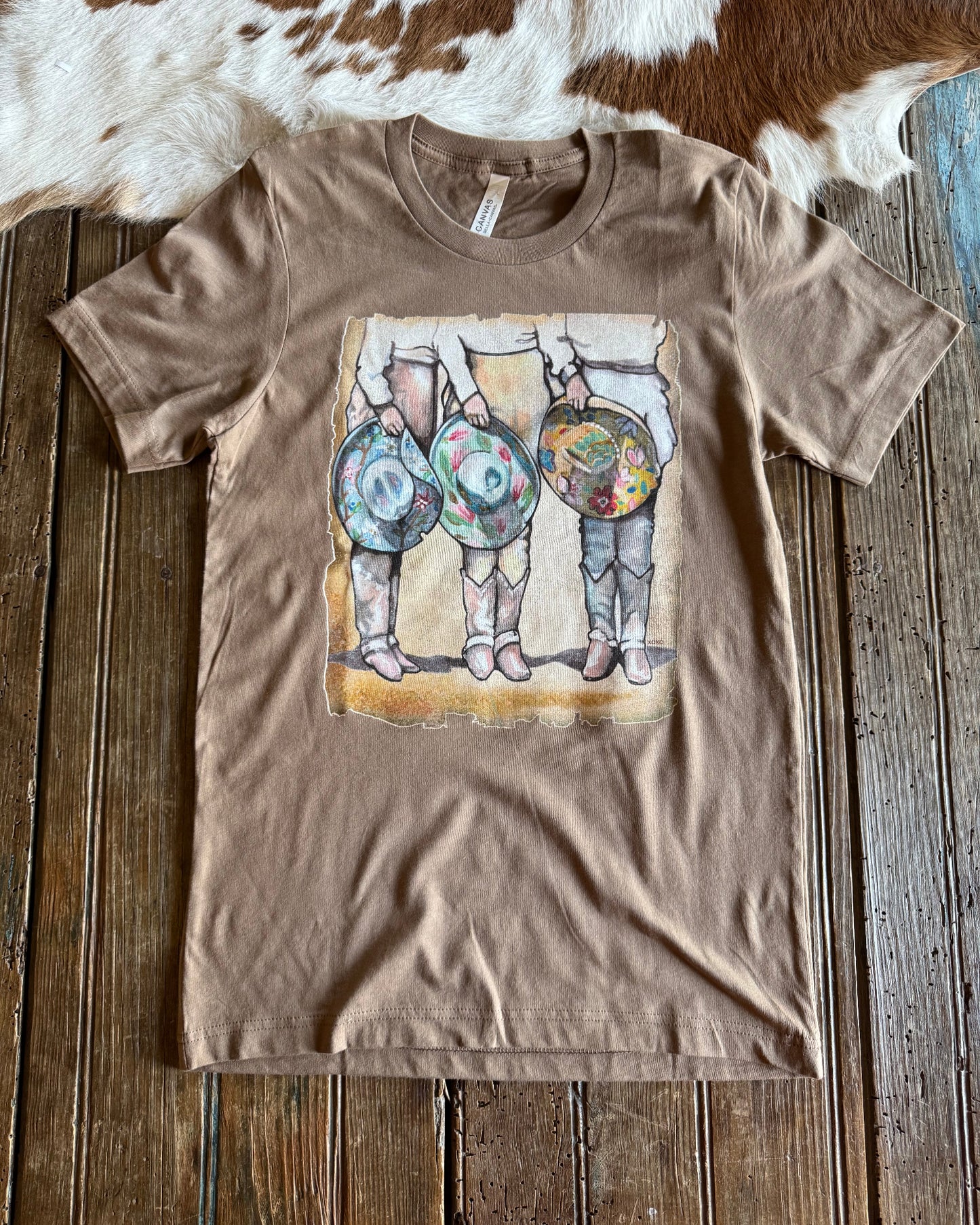 Cowgirls & Cowboy Hats graphic tee on rustic wood background