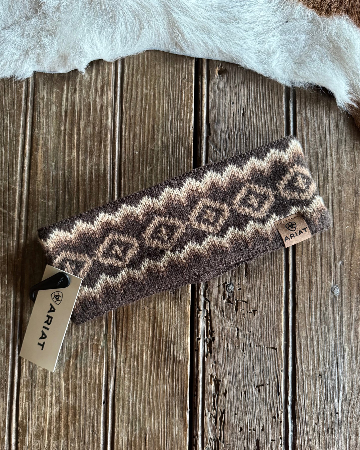 Patterned headband on a wooden surface with a cowhide rug in the background