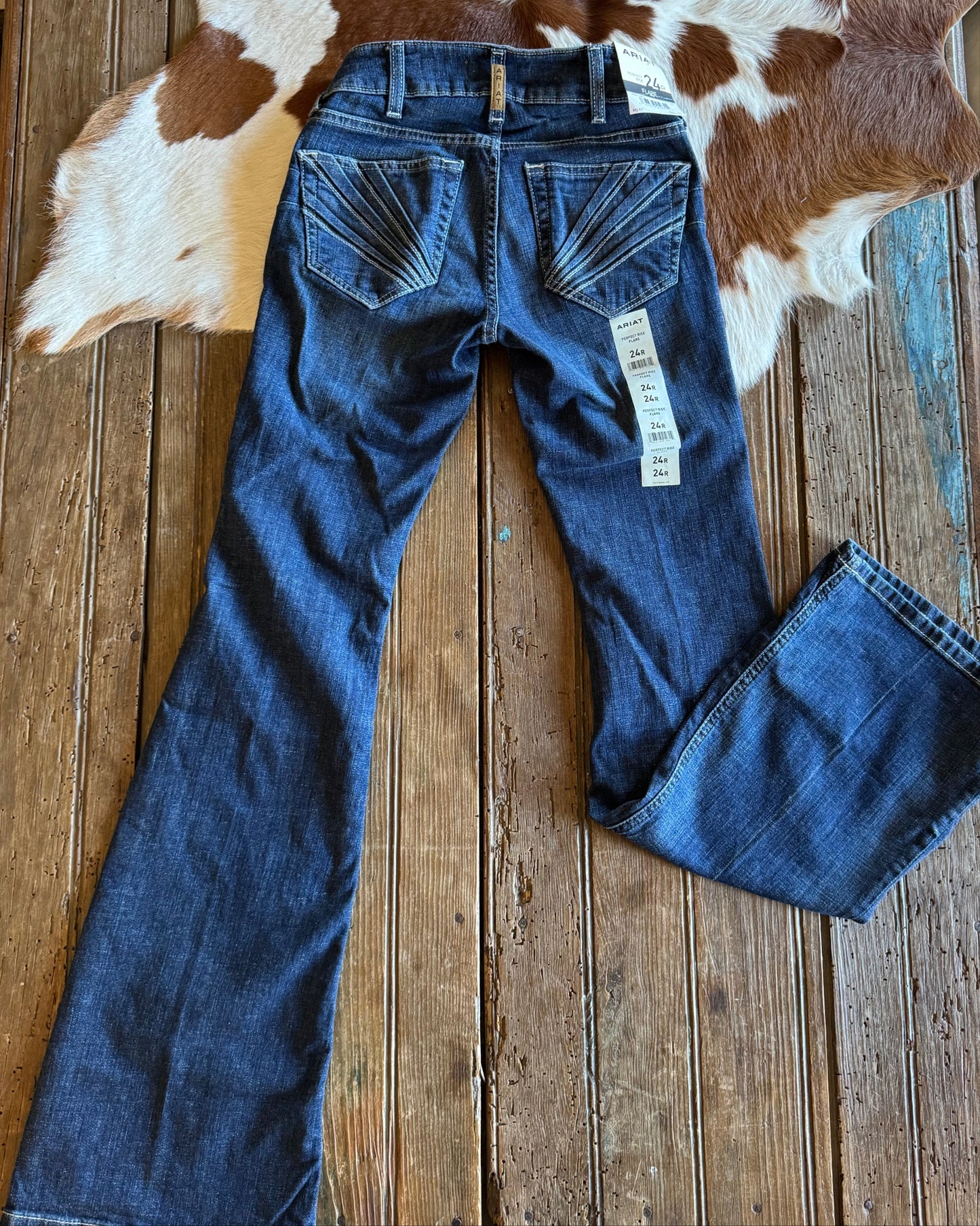 Back of distressed flare jeans on rustic wood background