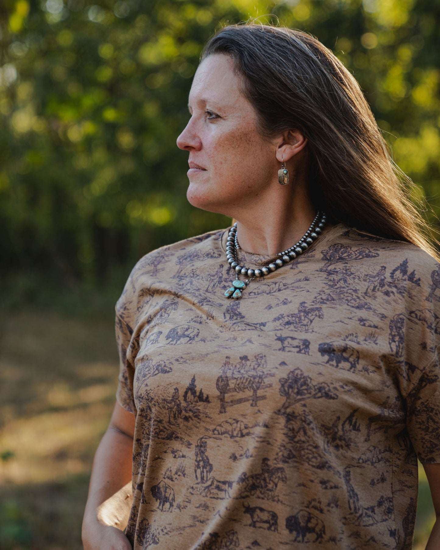 Woman wearing a patterned shirt with a blurred green background