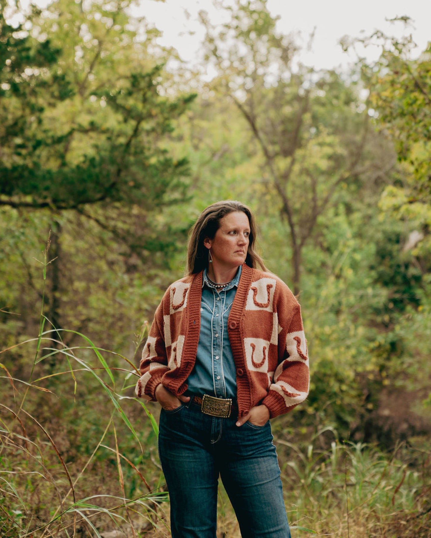 Woman wearing a patterned cardigan in a forest setting