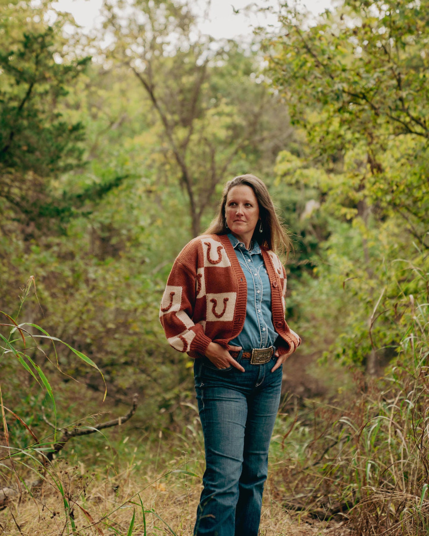 Woman wearing a patterned cardigan in a forest setting