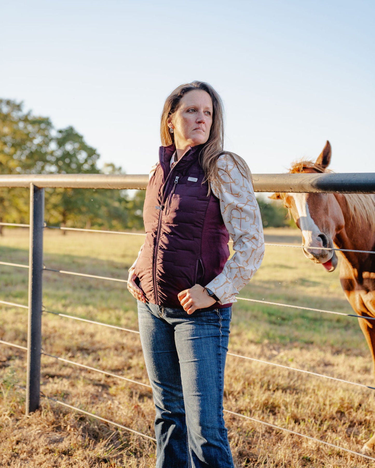 Woman standing next to a horse in an outdoor setting