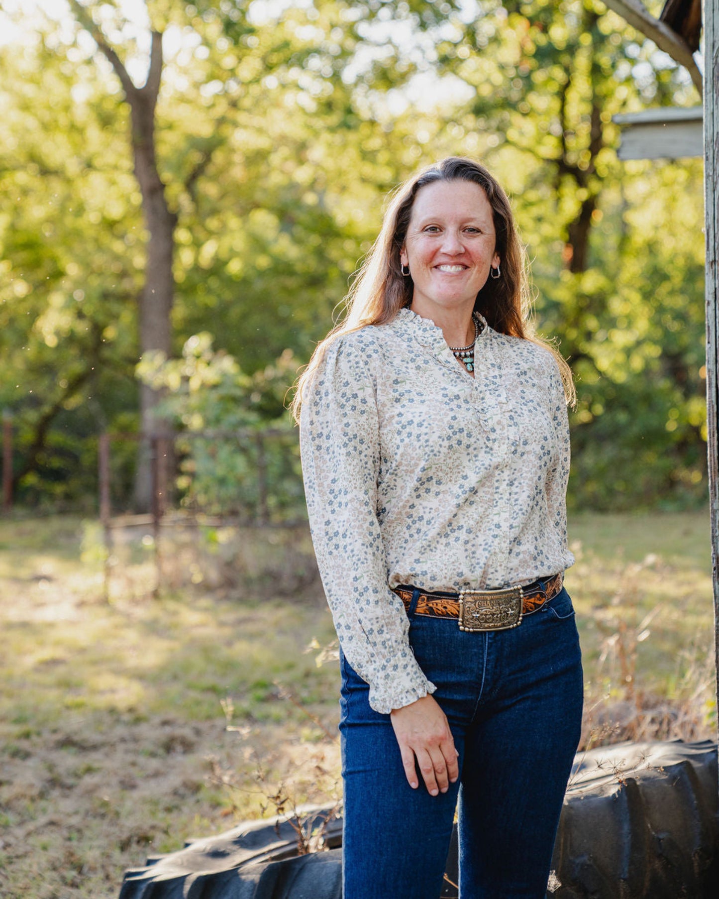 Woman standing outdoors with trees in the background
