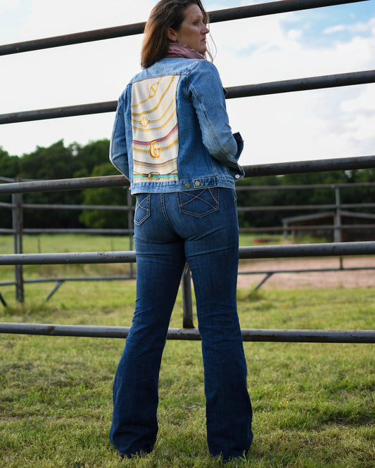 back view of Ella High Rise Slim Trouser Jeans on model with modern western outfit in front of fence