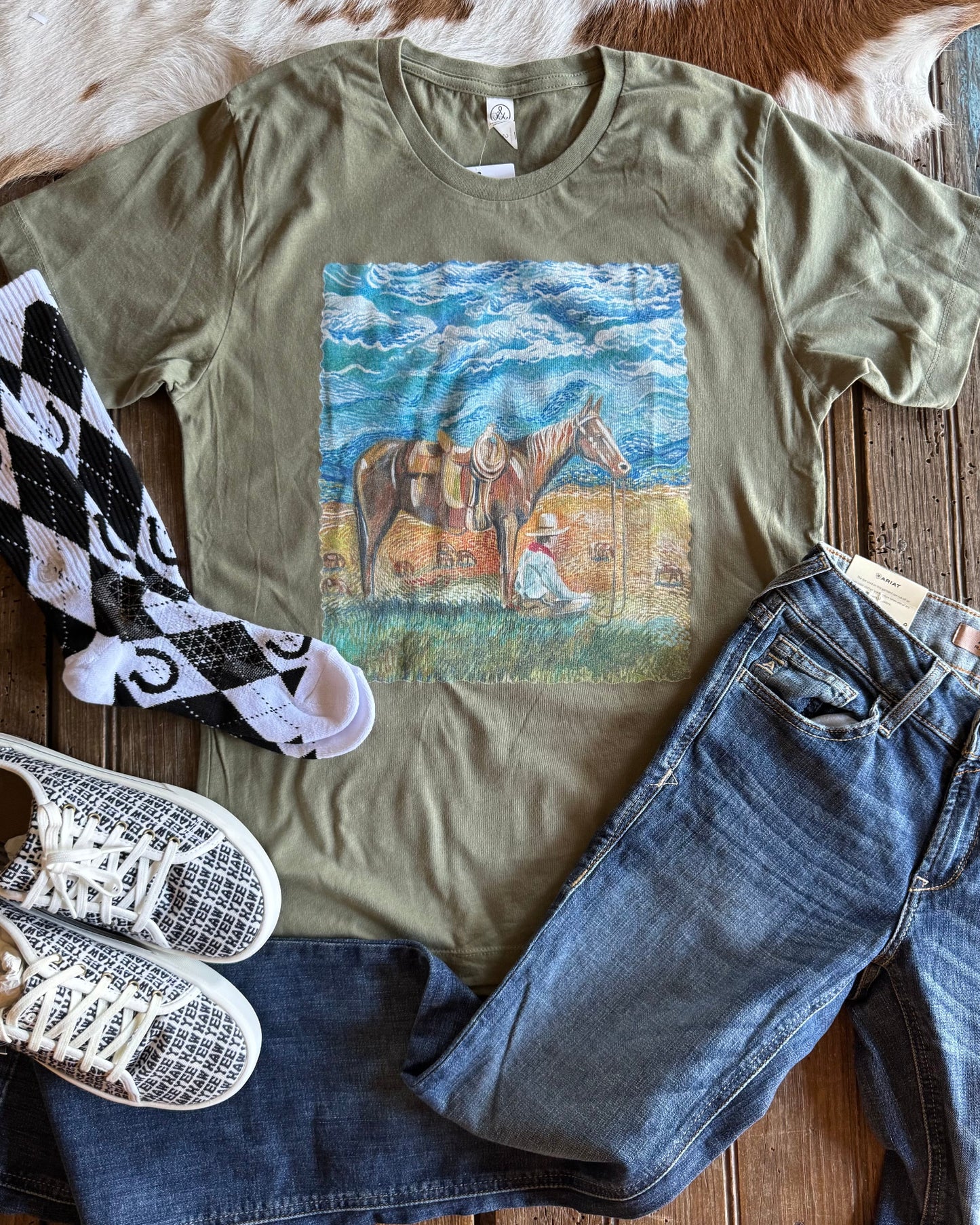 Home on the Range graphic tee with shoes, jeans and socks on a rustic wood background