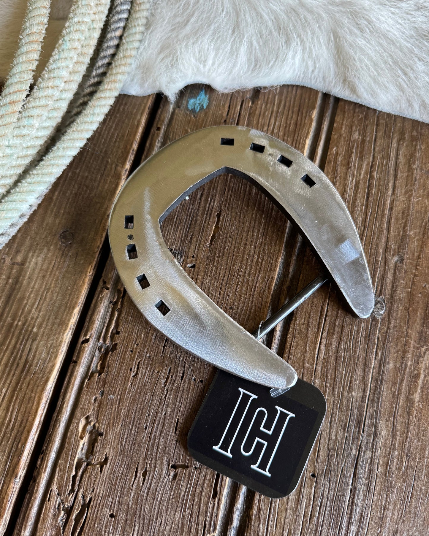 Horseshoe with a black tag on a wooden surface