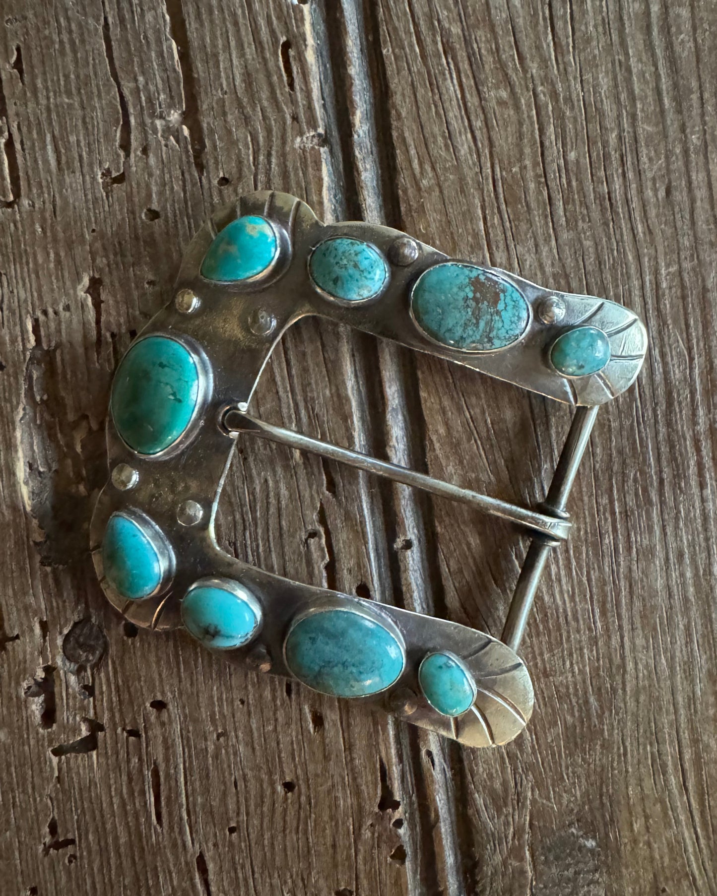 Horse shoe buckle 1 with turquoise on rustic wood background