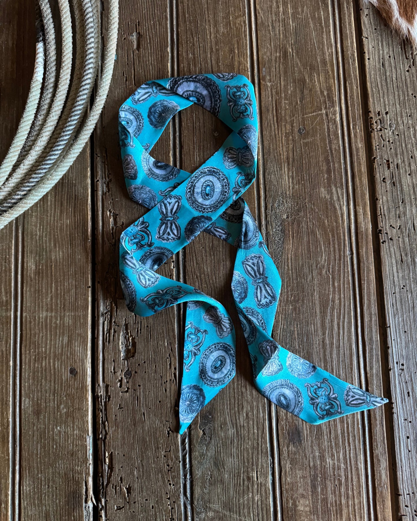 Blue patterned ribbon scarf on a wooden surface