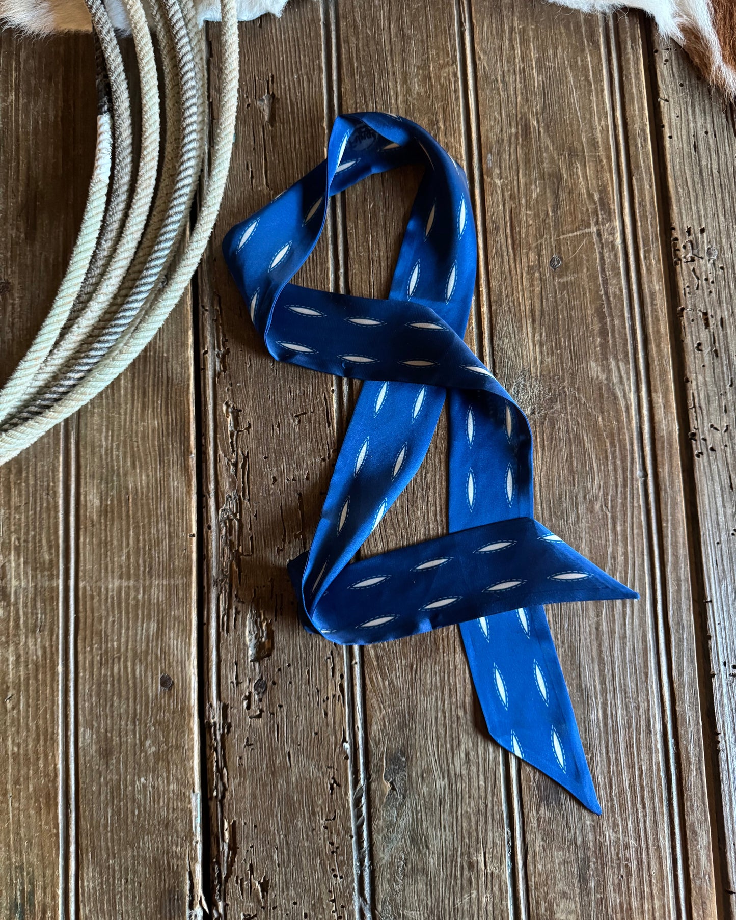 Blue ribbon scarf and white rope on a wooden surface