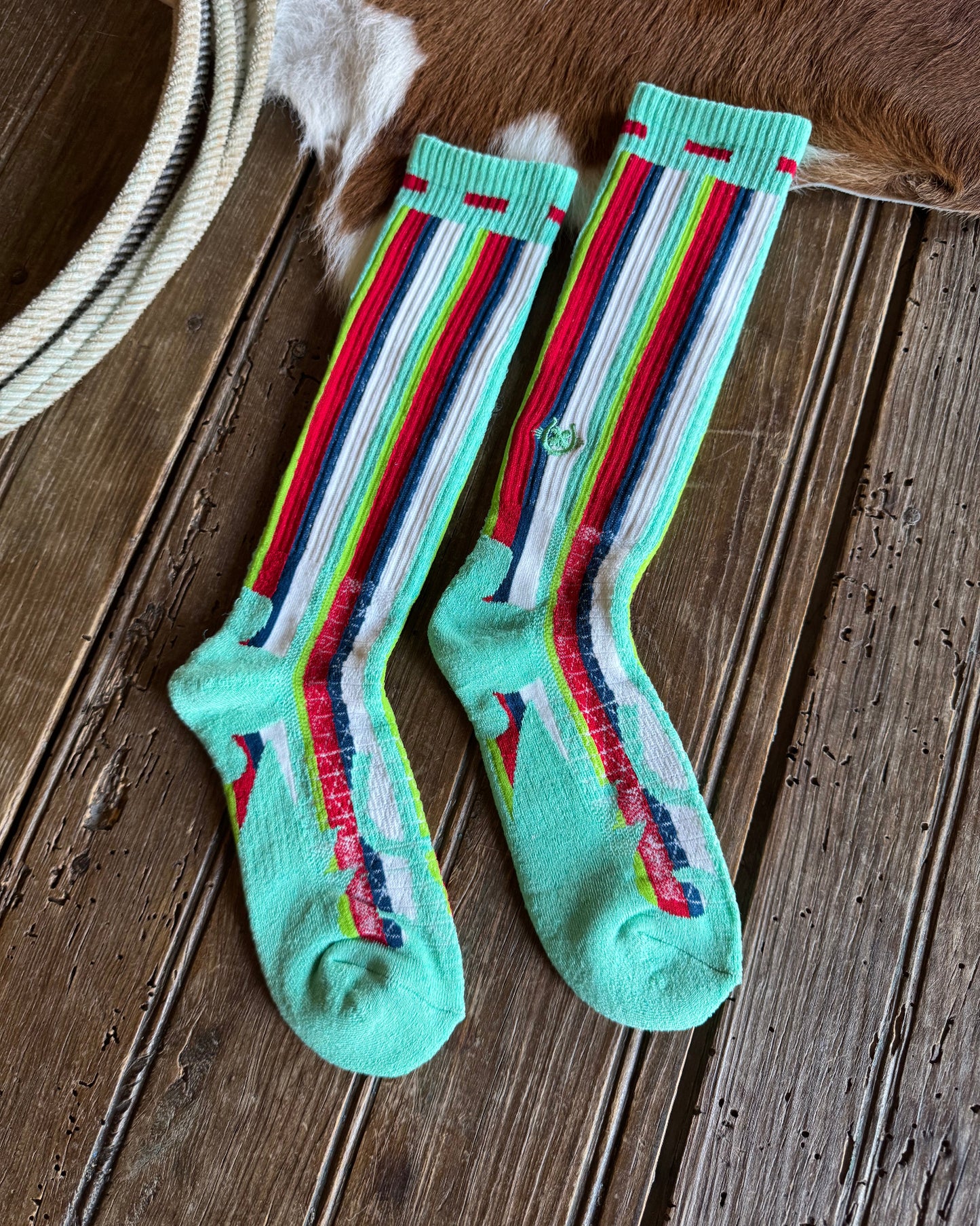 Pair of colorful striped socks on a wooden floor.