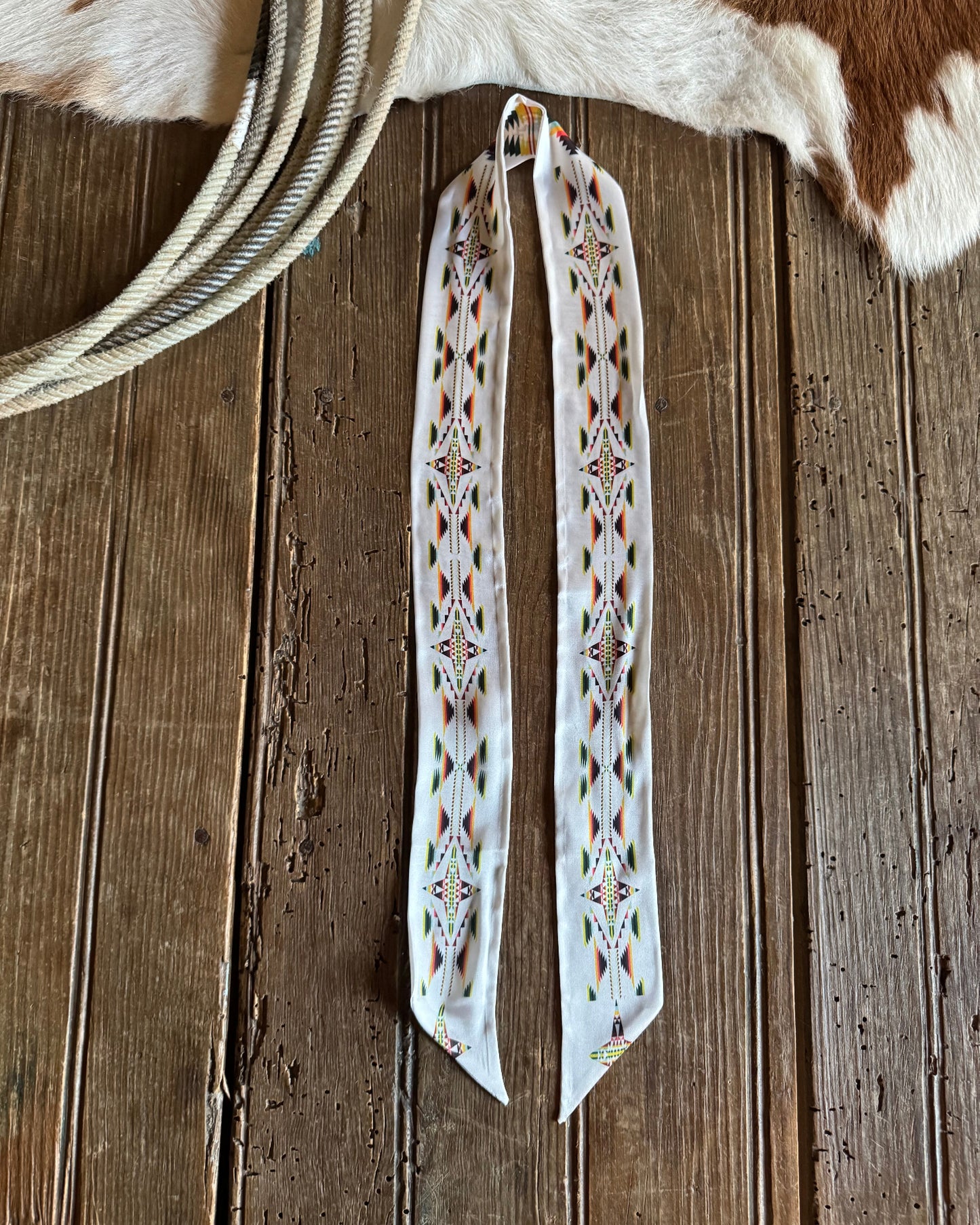 ribbon scarve with intricate patterns on a wooden surface.