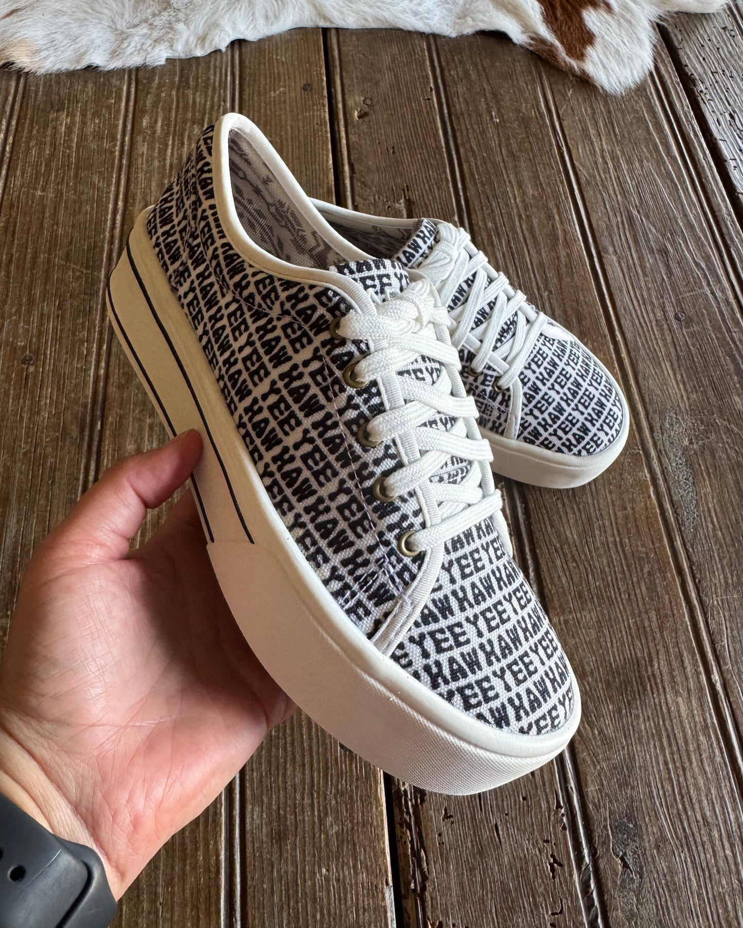 Close up of yeehaw printed sneakers with rustic wood background