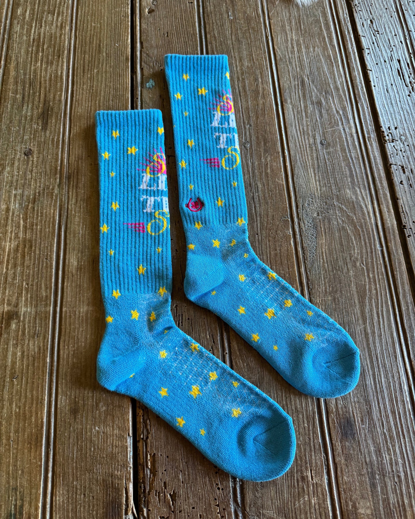 Shine Like a Star Performance Socks in turquoise on rustic wood background