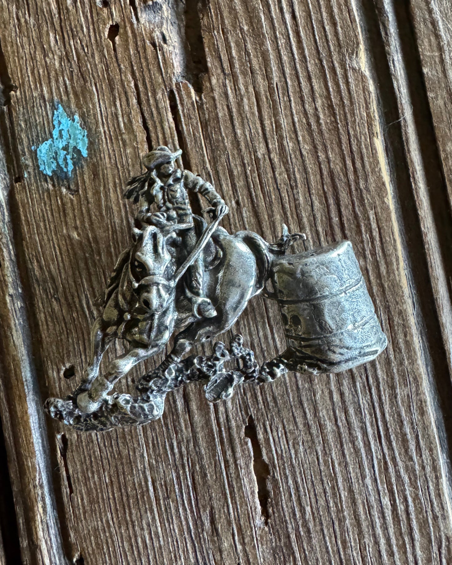 barrel racer pin on wooden background