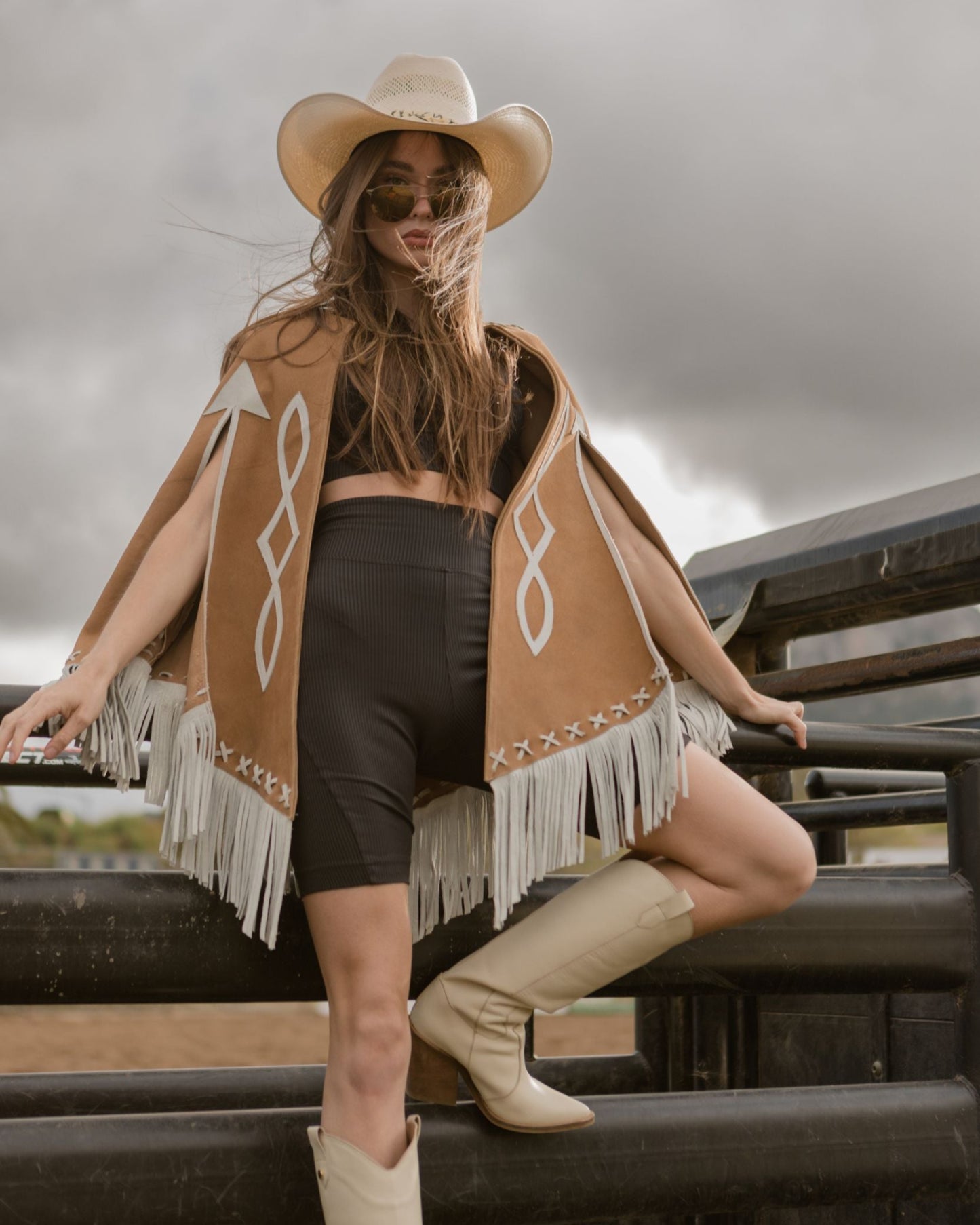 Model wearing a brown leather cape sitting on a bucking chute