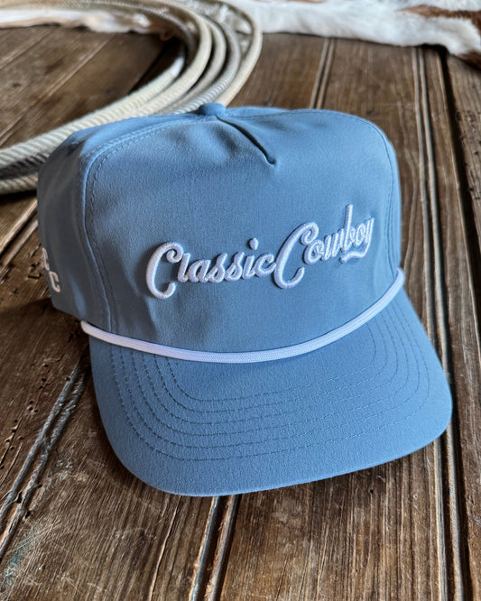 Blue bucket hat with 'Classic Cowboy' embroidery on a wooden surface