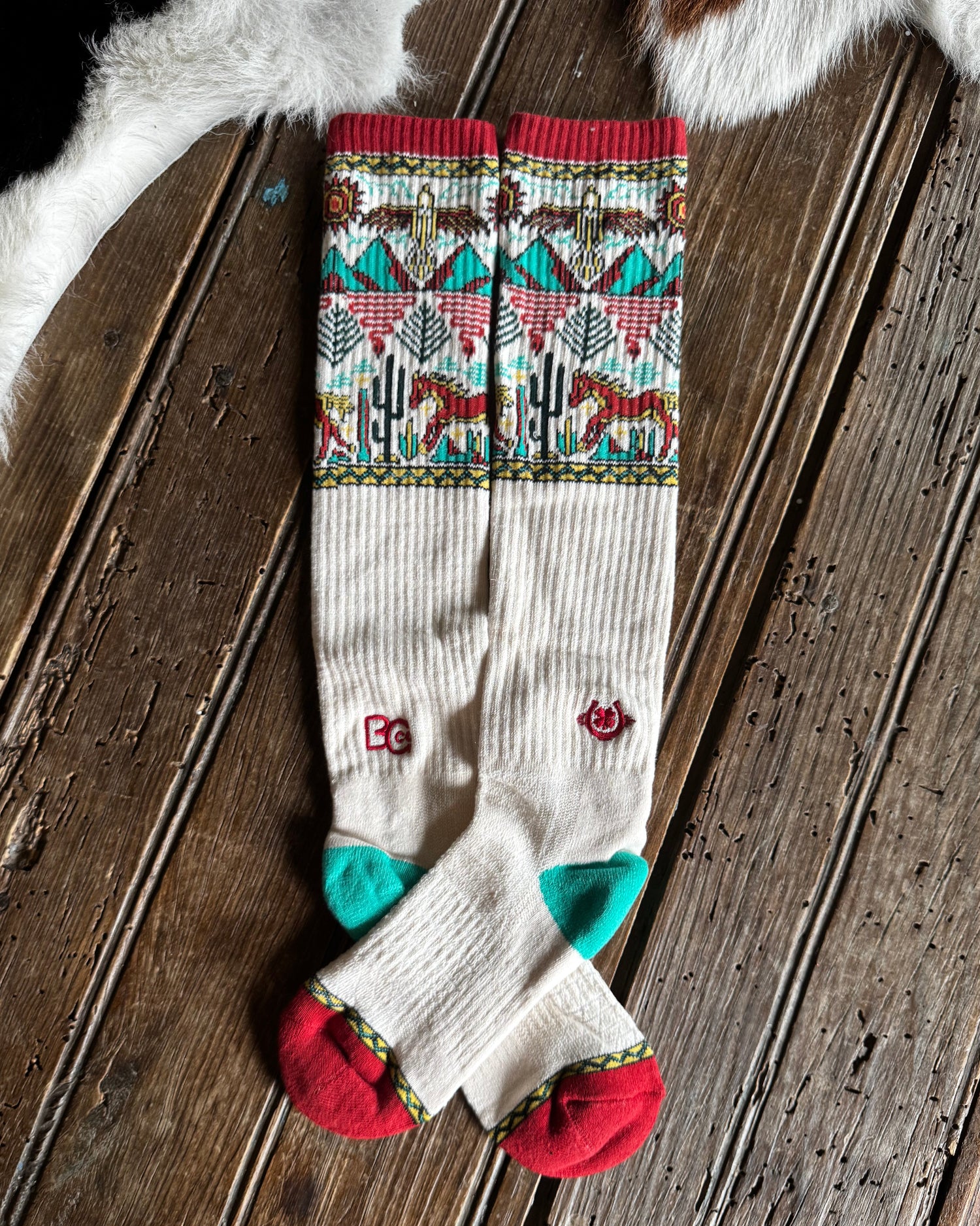 Colorful patterned socks on a wooden surface with animal fur