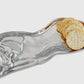 A silver metallic horse-shaped serving platter holding several round seeded crackers, shown on a light gray background.