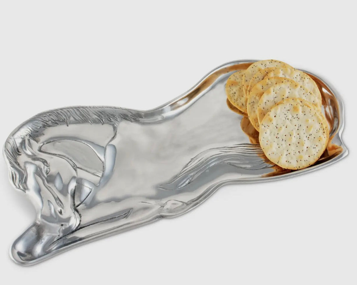 A silver metallic horse-shaped serving platter holding several round seeded crackers, shown on a light gray background.