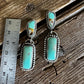 turquoise drop earrings on a wooden surface with a ruler for scale