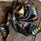 Colorful patterned scarf rolled up on a wooden surface