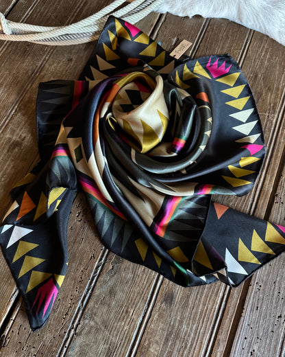 Colorful patterned scarf rolled up on a wooden surface