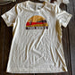 White t-shirt with a graphic design on a wooden surface
