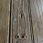 Full view of Briarwood Snaffle Bit Necklace on rustic wood background 