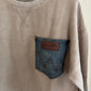 Beige sweatshirt with denim pocket on a hanger