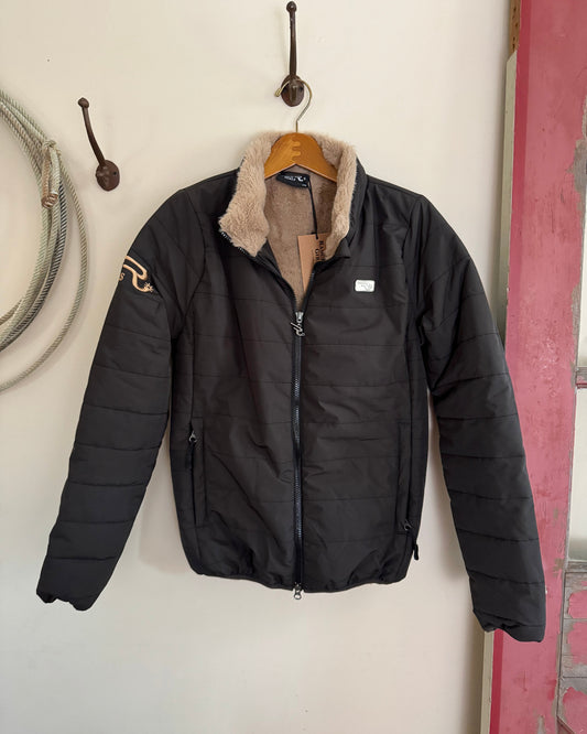 Black puffer jacket with fur lining hanging on a hook against a white wall.