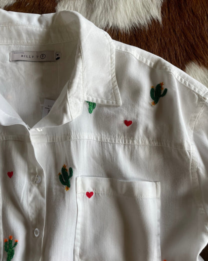 Close up of collar of white shirt with embroidered cacti