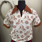 White shirt with brown pattern on a mannequin against a neutral background