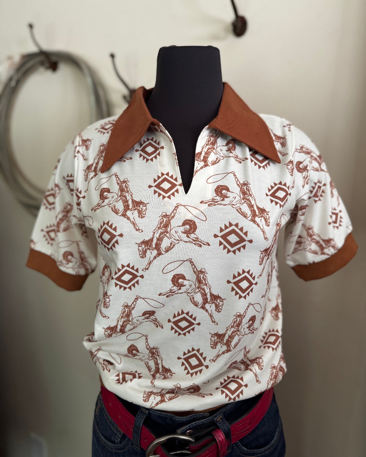 White shirt with brown pattern on a mannequin against a neutral background