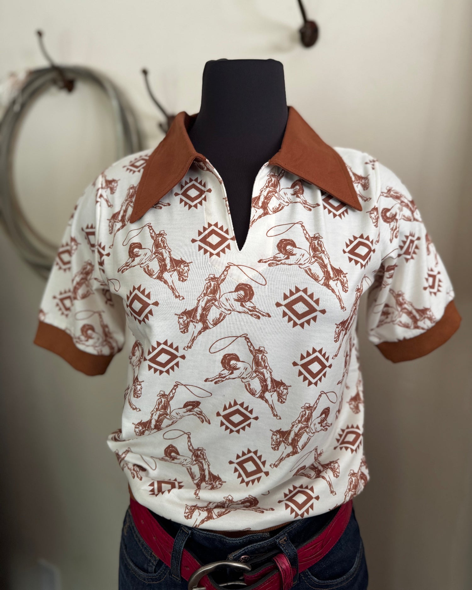 White shirt with brown pattern on a mannequin against a neutral background