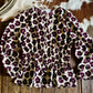 Floral print top on a wooden surface with a cowhide rug in the background
