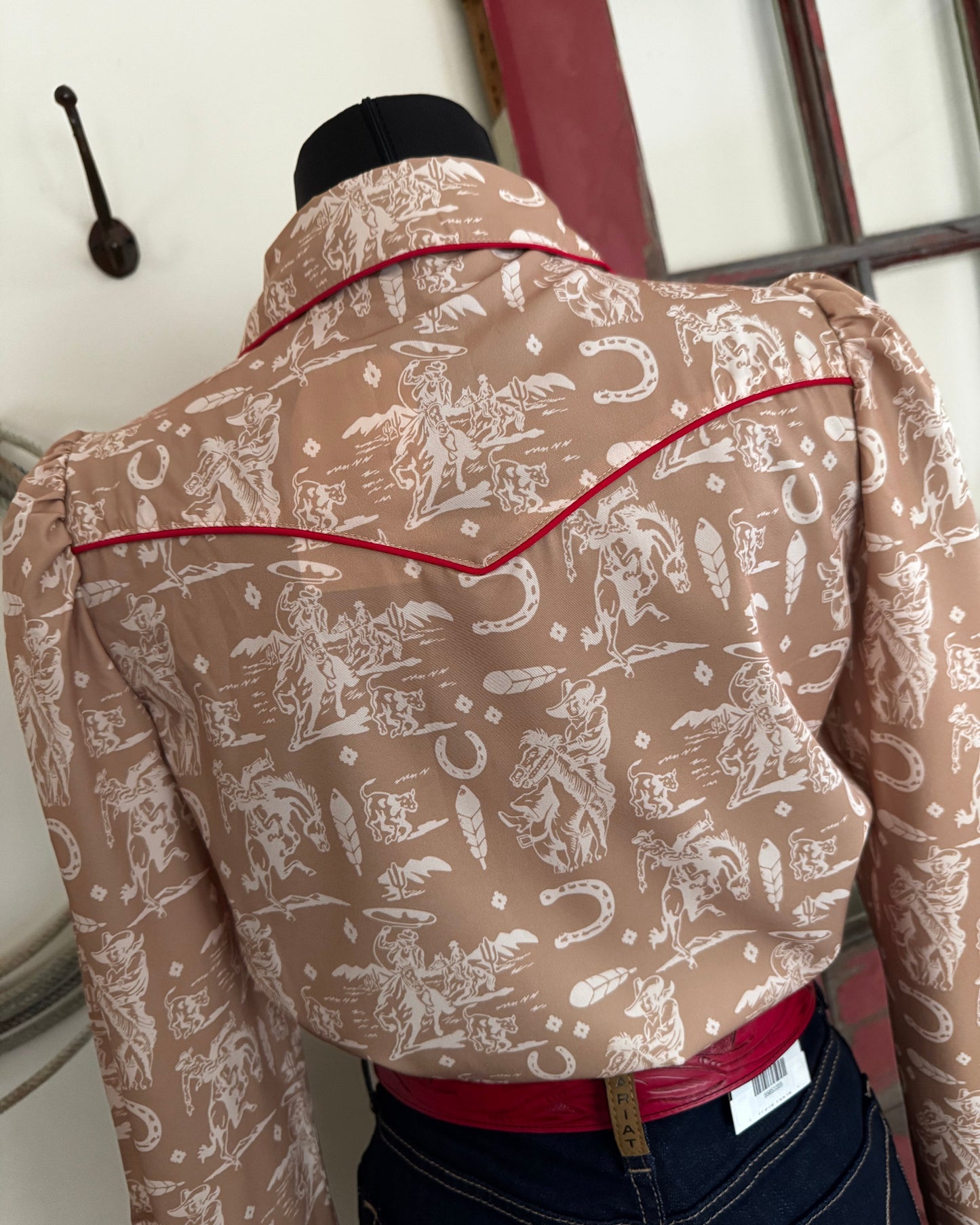 Brown patterned garment on a rack with visible tags.