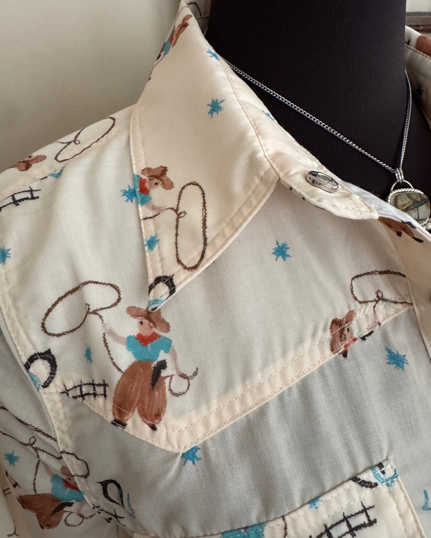 Close-up of a fabric with cowboy patterns on a neutral background