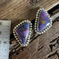 Pair of purple gemstone earrings on a wooden surface with a ruler for scale.