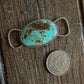 Turquoise stone twilly slide on a wooden surface with a coin for scale
