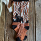 Pair of patterned socks on a wooden surface with a cowhide rug and rope.