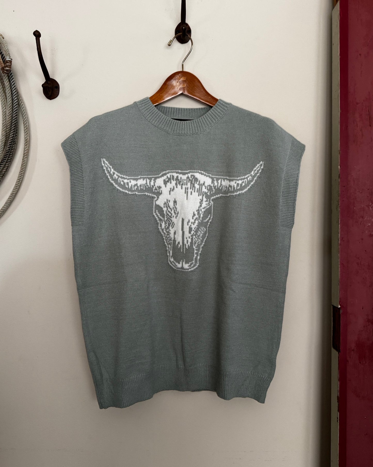 Green sweater with a white graphic on a white surface