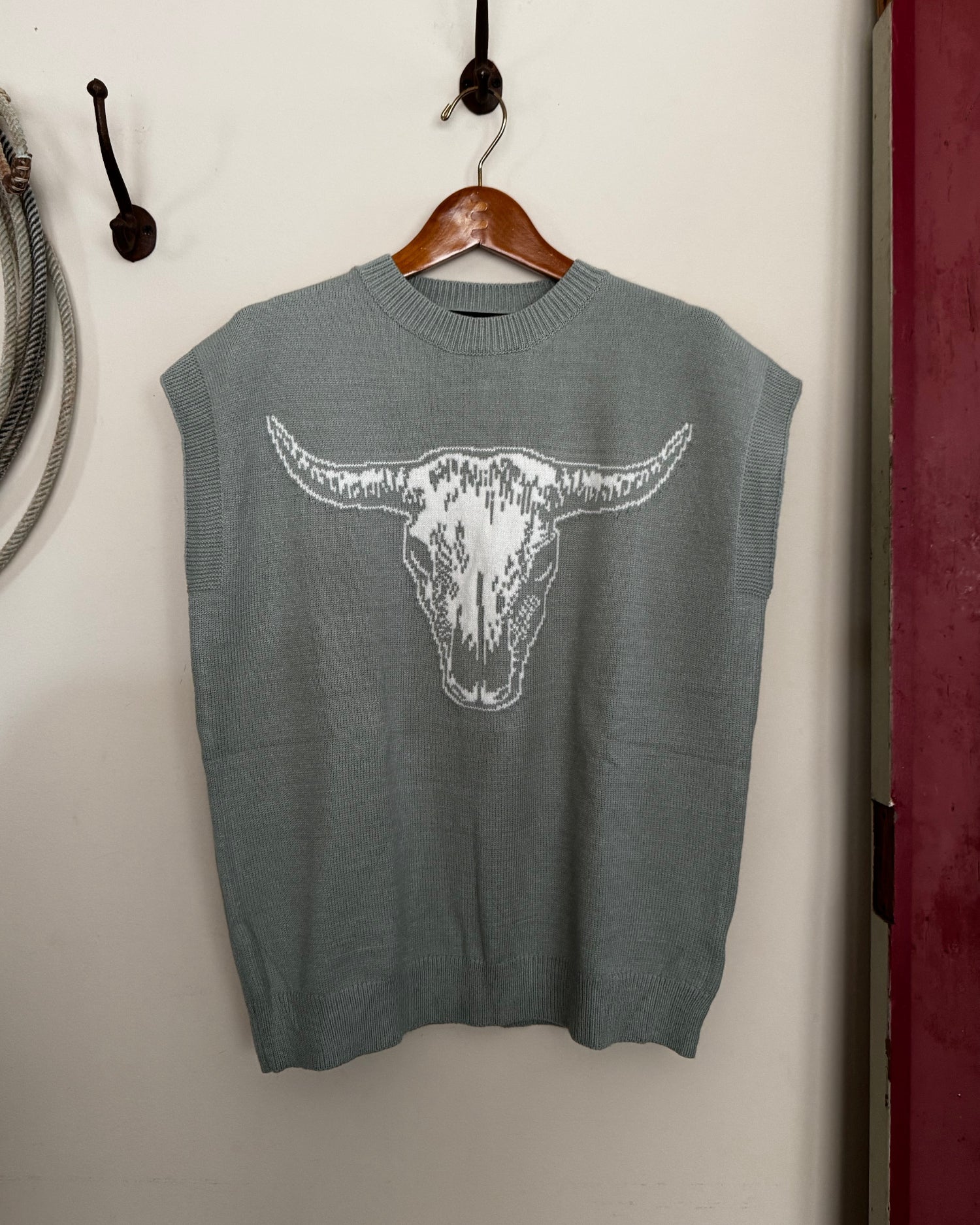 Green sweater with a white graphic on a white surface