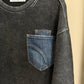 Black long sleeved shirt with a visible brand label on a beige background