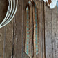 Ribbon scarf with geometric patterns on a wooden surface.