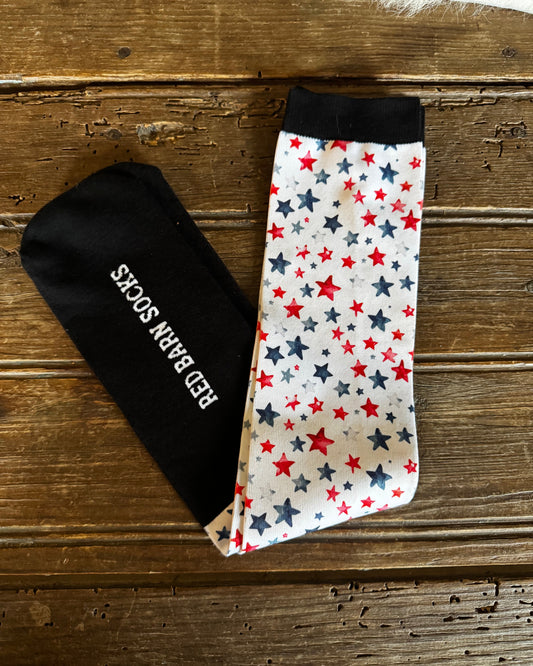 Black sock with 'Red White & Blue' text on a wooden surface