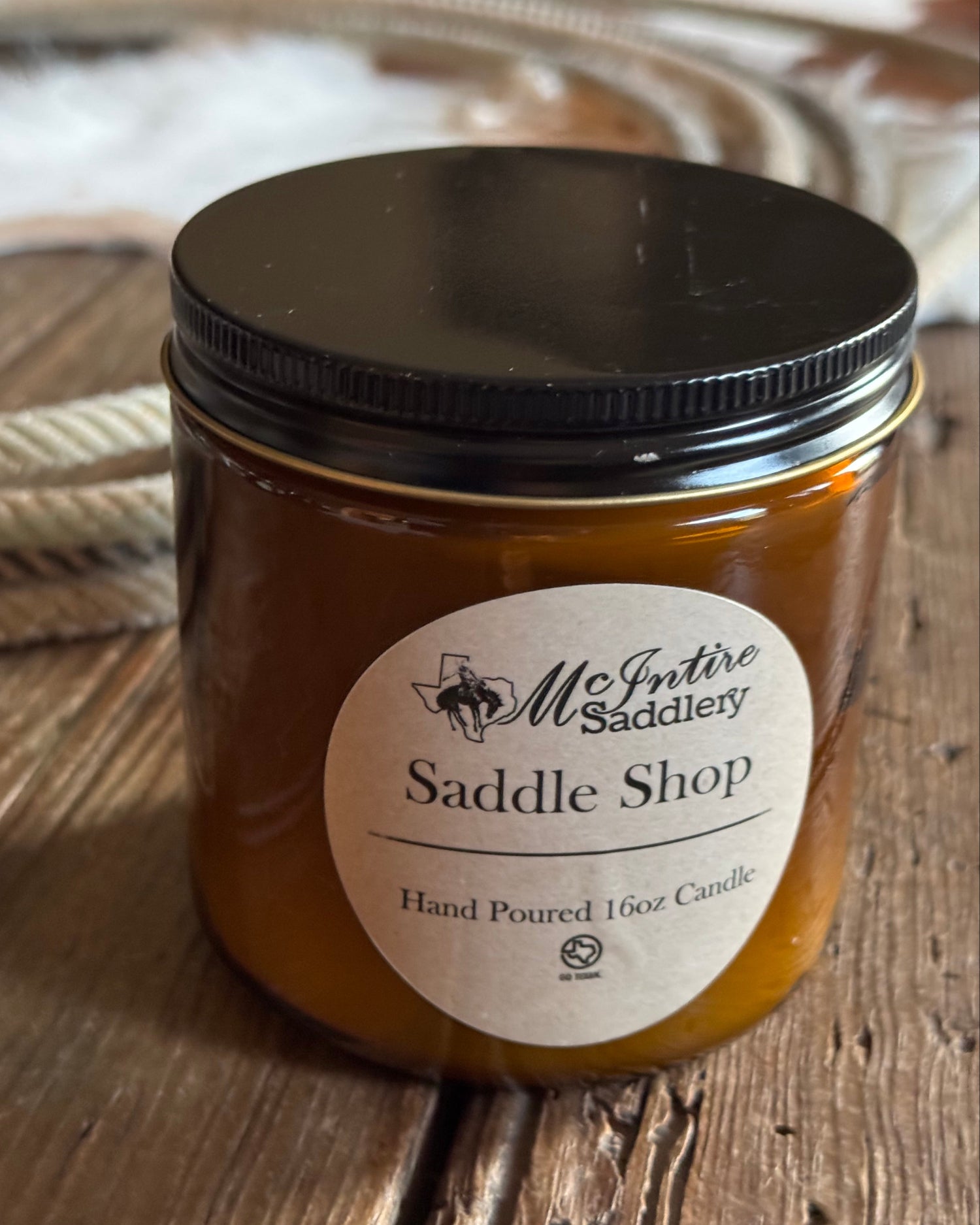 Jar of saddle shop product with a label on a wooden surface
