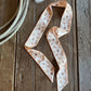 Ribbon scarf on rustic wooden background with rope featuring cowboys