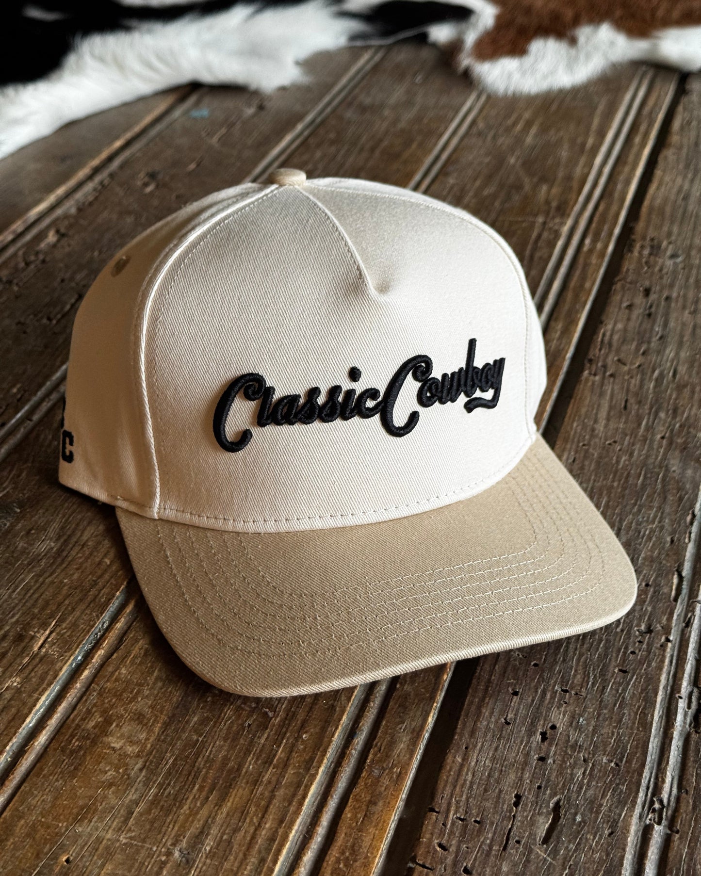 Beige cap with 'Classic Country' text on a wooden surface
