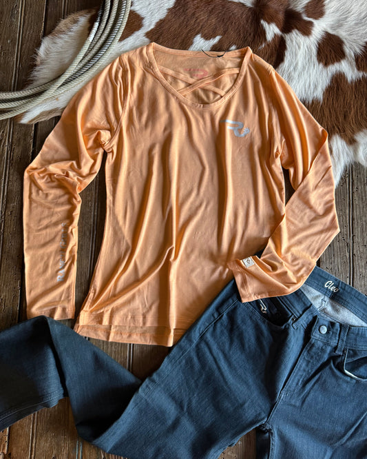Beige long-sleeve shirt and blue jeans on a wooden surface with cowhide rug